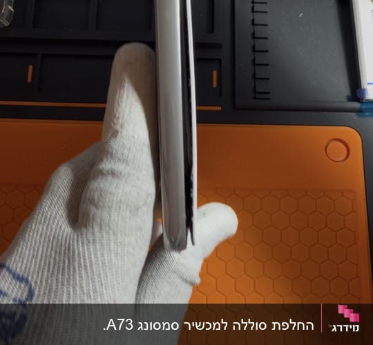 טלפון נייד עם גב מנותק בשל סוללה נפוחה בעמדת תיקון